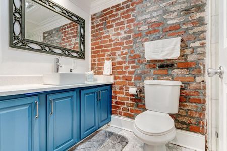 Full bathroom w/ tub & modern blue cabinetry.
