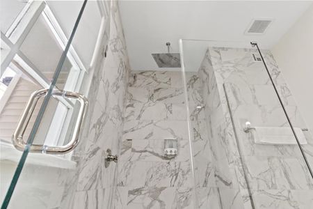 Stunning marble-look shower w/ rainfall-style fixtures — a luxurious rinse.