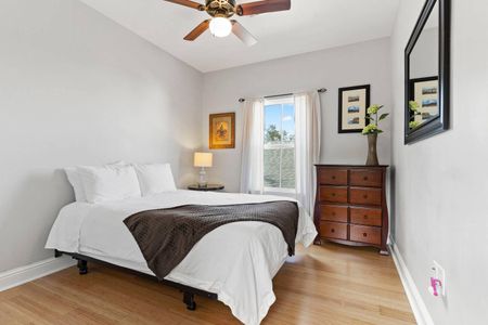 Cozy bedroom w/ a bed, warm wood dresser & soft natural light.