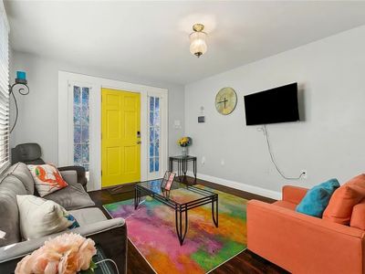 Welcome to your vibrant NOLA retreat! Relax in this stylish living space, filled with bold colors and cozy seating—perfect for unwinding after a day of exploring the Big Easy!"