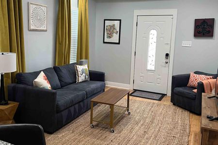Bright, airy living room w/ comfy sofa & warm natural light pouring in.