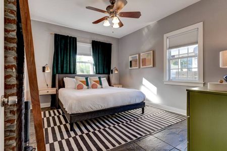 Restful master bedroom w/ a plush bed & bold striped rug to set the mood.