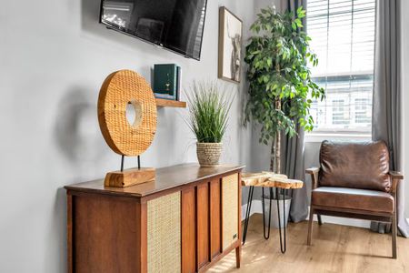 Rattan mirror & lush greenery bring a warm, natural touch to the décor.