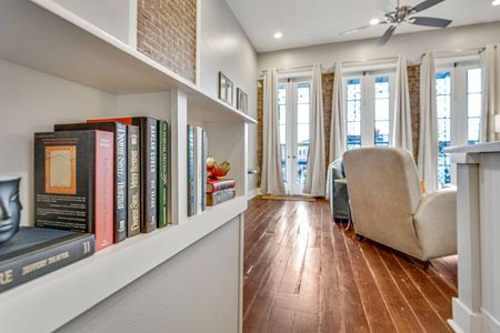 Charming hallway w/ warm wood floors & natural light leading through the space.