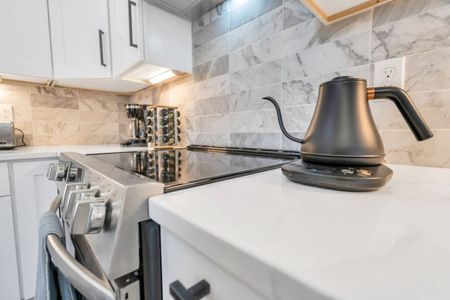 Luxe kitchen counter w/ marble finishes & a statement range hood.