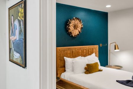 Step into a cozy, modern bedroom with bold accent walls, warm wood touches, and inviting lighting—perfect for a restful night.