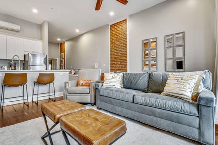 Sink into the plush sofa in this warm, brick-walled living room made for relaxing.