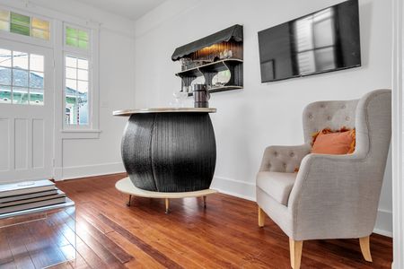 Striking bar island w/ a sculptural base & rich warm wood floors.