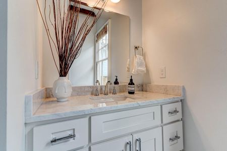 Half bath w/ a clean sink vanity & soft natural light.