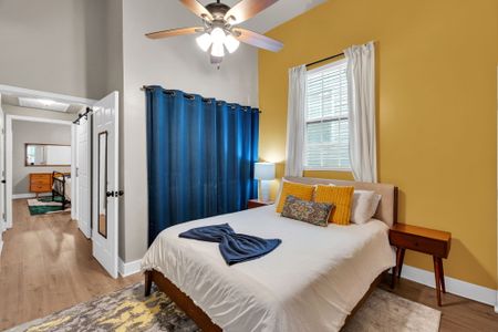 Cozy bedroom w/ warm mustard & blue tones & soft, layered bedding.