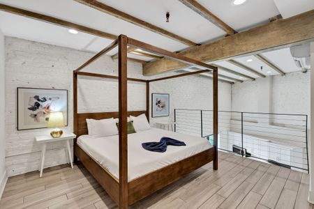 Sunlight pours into the lofted bedroom overlooking the open living room, blending charm and comfort in a space as vibrant and elevated as the Crescent City itself.