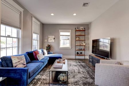 Cozy living room w/ blue sofa & warm tones — a welcoming spot to unwind after a day out.