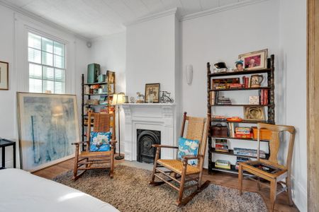 Classic NOLA living room w/ a cozy fireplace as its centerpiece.