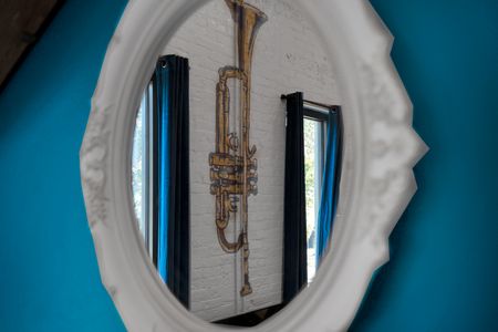 A saxophone reflected in a teal mirror captures the home's jazzy, artistic spirit.
