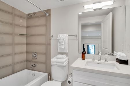 Enjoy a sparkling clean space with a full tub, fresh towels, and a wide vanity—perfect for getting ready or winding down.
