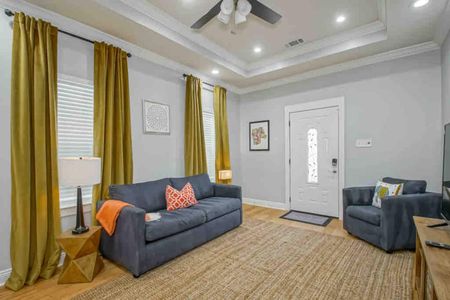 Sink into the plush sofa & catch up on your favorite shows in this welcoming living room w/ golden curtains.