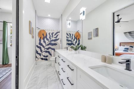 Upstairs Jack & Jill en-suite full bath w/ double sinks & fresh white finishes.