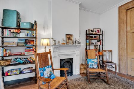 Cozy reading nook anchored by a classic fireplace.