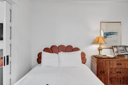 Bedroom w/ a bold statement headboard & warm, layered bedding.