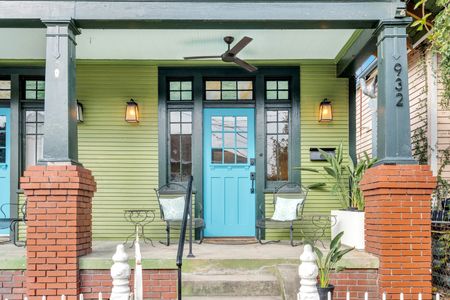 Welcoming front patio w/ seating tucked beneath a classic lantern.