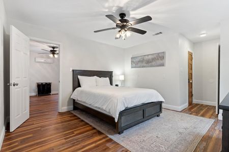 Queen bedroom w/ warm wood floors & a ceiling fan — comfortable & relaxed.