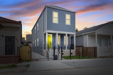 Striking blue exterior glowing at dusk — a home that turns heads.