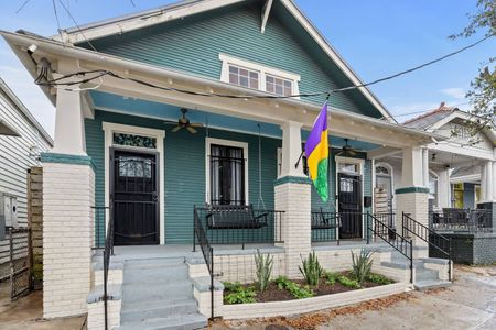 Charming teal shotgun-style home w/ a classic porch & vibrant curb appeal.