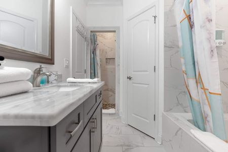 Light & airy bathroom w/ shower & colorful curtain detail.