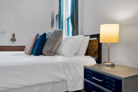 Bright, cushioned sofa w/ bold blue & mustard pillows — a cheerful spot to lounge.