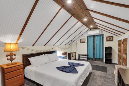 Loft-style bedroom w/ twin beds tucked under slanted ceilings — full of charm.