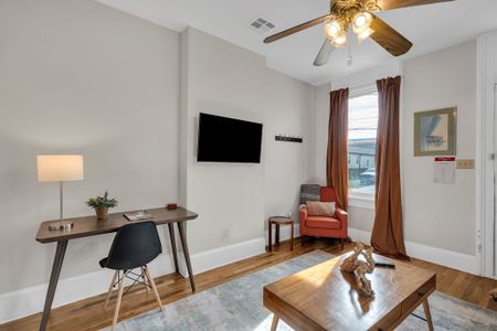 Relaxed living area w/ wall-mounted TV & a small workspace for when you need to plug in.
