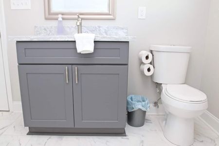 Second bathroom w/ grey cabinetry & all the essentials within reach.