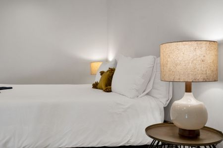 This cozy nook features soft lighting, fresh linens, and a calm vibe—great for catching up on rest after a day in the city.