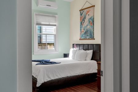 Bright bedroom w/ soft linens & peaceful natural light streaming in.