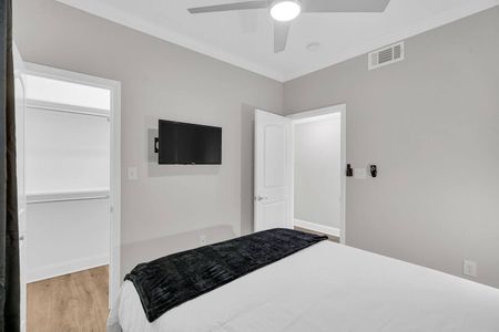 Comfortable bedroom w/ a wall-mounted TV for easy late-night streaming.