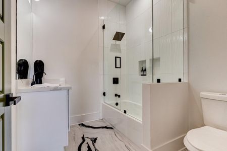 Luxe master bath w/ glass-enclosed shower & rainfall showerhead.