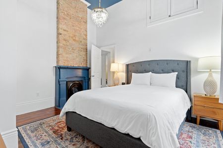 Cozy queen bedroom w/ a tufted headboard, fireplace & crisp white linens for a restful night.