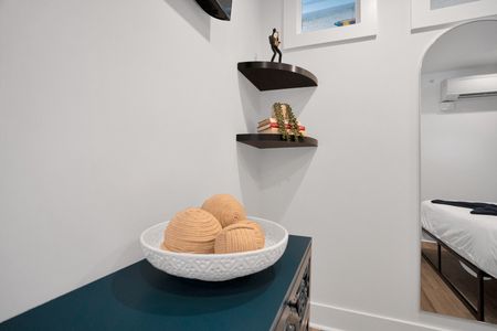 Sculptural woven bowl on a white shelf brings minimalist coastal warmth to the room.