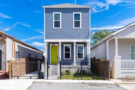 Charming blue home w/ iconic yellow door, inviting curb appeal at its best.