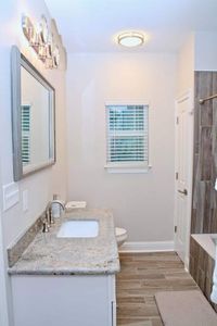 Bright, clean second hall bathroom w/ a sink & vanity mirror.