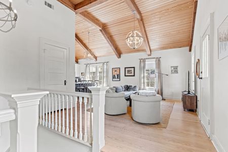 Spacious living room w/ vaulted wood ceilings & natural light.