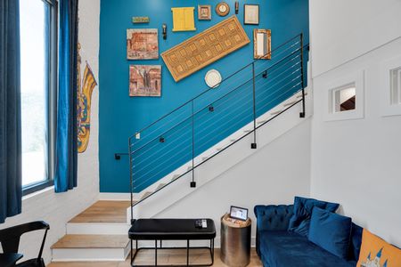 Vibrant teal staircase wall adds a pop of color & artistic energy to the space.