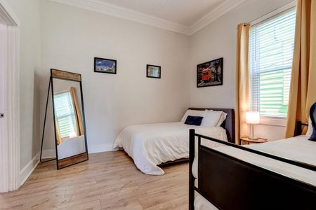 Second bedroom w/ two twin beds, a full, & a full-body mirror — room to spread out.