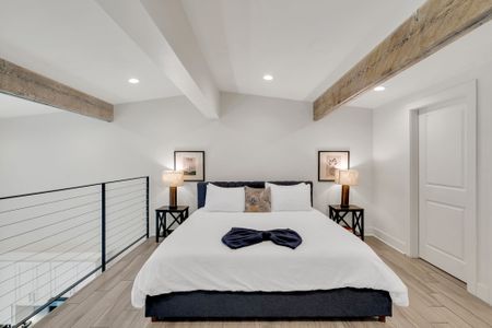 Airy upstairs bedroom w/ exposed beams & crisp bedding for a restful stay.