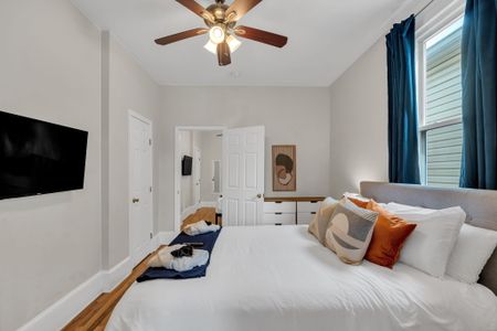 Light-filled bedroom w/ warm tones & a neatly made bed.