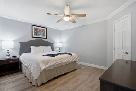 Serene bedroom w/ soft linens & warm wood floors to rest & recharge.