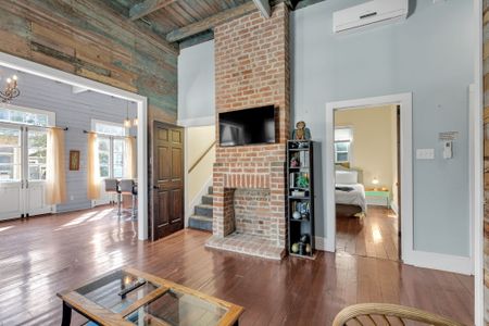 Brick fireplace anchors the living space w/ warmth & classic NOLA character.