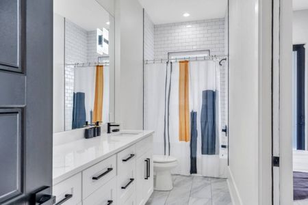 Modern bathroom w/ a sleek wood-paneled accent wall & contemporary fixtures.