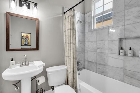 Clean, light-filled bathroom w/ a sink & tub — simple, fresh & functional.
