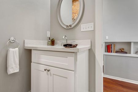Bright bathroom w/ a round mirror & sink vanity — fresh & functional.